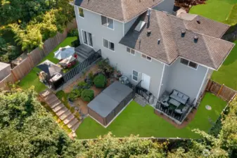 Expansive back yard w/ outdoor kitchen, multiple entertaining areas, Swim Spa & garden beds