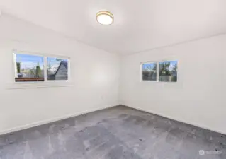 Relax in this tranquil bedroom, where large windows frame peaceful views and provide abundant natural light. The neutral tones and plush carpeting create a cozy retreat for restful nights.