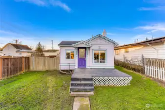 This view emphasizes the charm of the large, fully fenced front yard. The classic white picket fence complements the cottage’s aesthetic and offers a secure space for pets, gardening, or enjoying the outdoors.