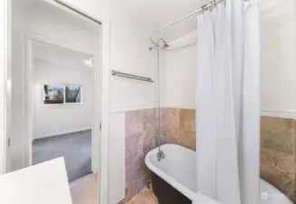 An elegant claw-foot bathtub adds a touch of vintage charm to this updated bathroom. The tiled walls and modern accents blend classic style with contemporary functionality.