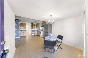 The open layout dining area flows seamlessly into the kitchen, offering a versatile space for meals and entertaining. Updated light fixtures and a neutral palette create a fresh and inviting atmosphere, perfect for hosting.