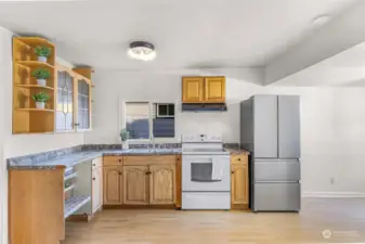 This spacious kitchen combines functionality with charm, featuring ample cabinetry,  appliances, and plenty of counter space for meal prep. Natural light floods the space, highlighting its warm and welcoming design.