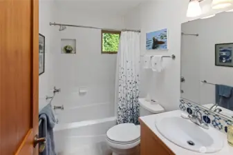 Full bath with tile accents and lots of natural light, off 2nd BR/hallway, utility rooms.