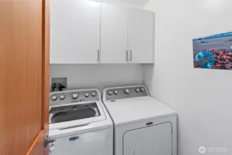 Utility room has washer/dryer and cabinets, closet accross hall.