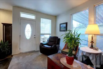 Step inside this bright and welcoming living area, where a large window and a front door with an elegant oval window fill the space with natural light. The open layout seamlessly connects the living room to the entryway, creating a spacious and comfortable feel. This area is perfect for relaxing after a long day or greeting guests.