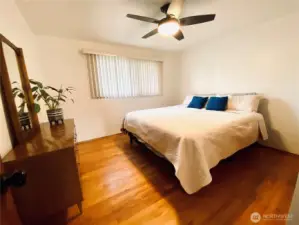 Primary bedroom facing the front of the house with beautiful original hardwood floors. This is a California King bed which leaves plenty of room for nightstands on each side! Enjoy overhead ceiling fan in the summer along with central A/C.