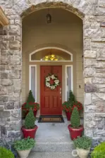Elegant stone archway sets the tone as you approach the covered porch.