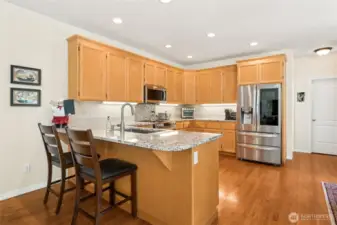 Stylish, spacious kitchen featuring granite countertops and newer stainless appliances.