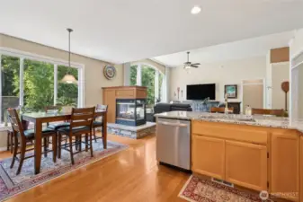 A centrally placed multi-sided fireplace adds cozy ambiance to the kitchen and living areas.
