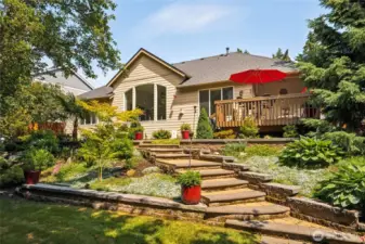 Back of home features graceful stairs connecting each outdoor level.