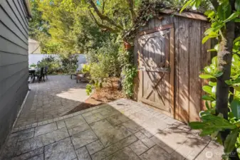 New stamped concrete garden shed patio. Rustic garden shed blends right in the mature landscaping.