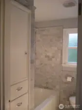Main level bath with Carrara marble. Built-ins for convenient storage.