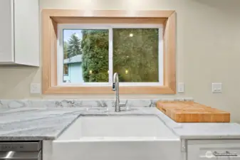 Farm style sink looks perfect below the wood wrapped window.