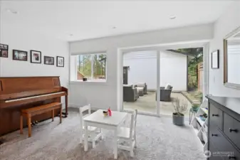 Downstairs gathering space with view out to the paved patio.