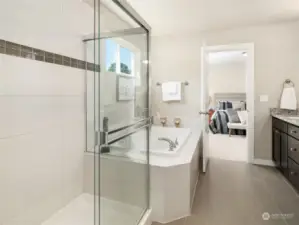 The primary bathroom is impressively appointed with dual vanities, quartz counters, a luxurious soaking tub and a tiled walk-in shower.