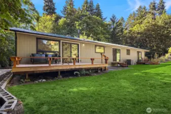 From Backyard looking from Left to right-Deck w Living room behind, Kitchen in Center, Primary to the right w 2 chairs on Landing deck