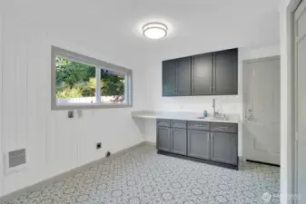 Laundry room includes a closet door with built in ironing boards