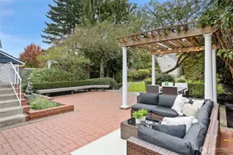 Backyard patio facing bench and rear entry of home.