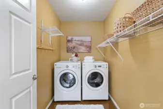 Spacious laundry room with hanging racks and storage.