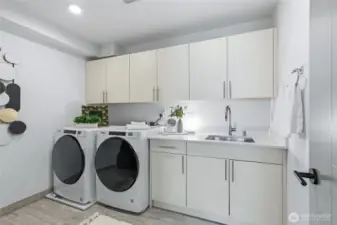 Another bonus - an oversized laundry room with an utility sink, built in cabinetry and additional storage room.