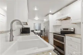 SECOND VIEW OF THIS MODERN KITCHEN WITH BRUSHED NICKLE FAWCET GARDEN SINK RECESSED LIGHTING AND OPEN TO GREAT ROOM.  THERE ARE TWO EATING AREAS FOR YOUR GUESTS TO ENJOY THE WATERFRONT LIVING