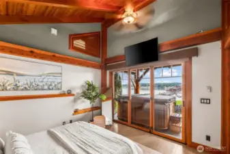 Primary  bedroom looking out onto the patio and hot tub.  Escape to the hot tub around the corner through the bathroom door.
