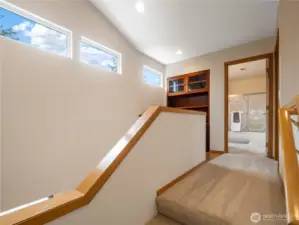 The staircase upstairs is open to the living spaces below on either side.