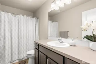 Full upstairs bathroom features a spacious vanity, modern lighting, and a tub/shower combo—perfect for everyday convenience