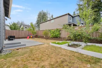 Enjoy the fully fenced backyard complete with a spacious patio, fruit trees, raised garden beds, and room to play or entertain year-round