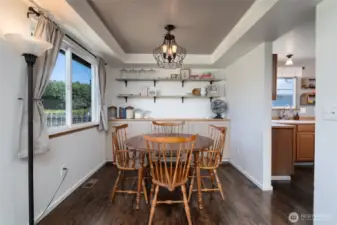 Dining area is located off kitchen and opens to living room. The trayed ceiling, beautiful built-in cabinet and shelving offer a stylish space to  entertain.