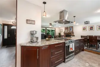 The beautifully updated kitchen features rich dark-toned cabinetry, stainless steel appliances, an oversized peninsula, and abundant counter space and storage.