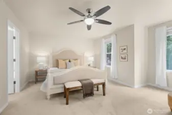 The spacious primary bedroom looks out to the back of the house and over the greenbelt. In the Winter, a small, peak-a-boo water view can be found.
