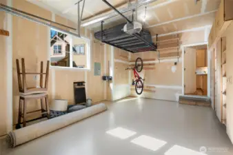 1 of 2 garage with overhead storage and built-in cabinetry.