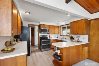 Efficiently laid out kitchen with laminate flooring, plenty of counterspace and storage.