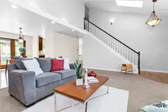 Cozy living room with vaulted ceiling, adjacent to formal dining area.