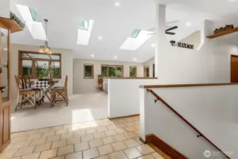 Step inside to discover an expansive main level offering approximately 1,880 square feet of warm, light-filled living. Vaulted cathedral ceilings and multiple skylights elevate the space, while large windows bring the beauty of the outdoors in.