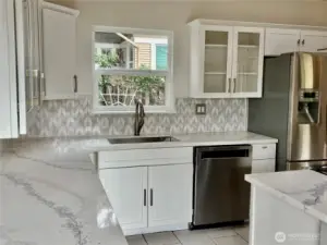 Large stainless sink under the picturesque window.