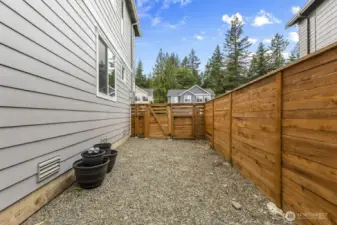On the side of the home, a gravel section with a double gate fully opens—ideal for storing smaller recreational toys and gear.