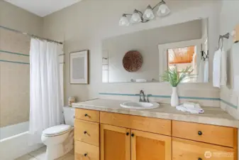 Primary bath functions as a shared bath, door to primary is on right, and door to the rest of the house is reflected in the mirror.