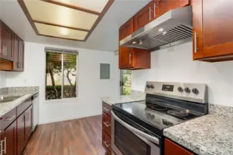 The kitchen boasts warm-toned cabinetry, granite countertops, and stainless steel appliances.