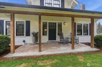 Covered front porch overlooking partially fenced yard.