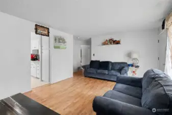 Hallway ahead leads to the bedrooms and bathroom. Doorway on left leads to Kitchen.