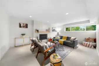 Light & bright lower level family room with gorgeous centerpiece gas fireplace surround.