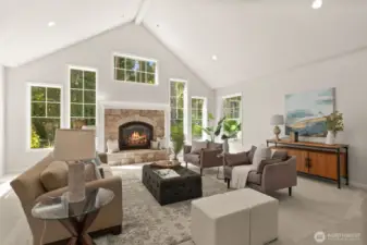 A grand entryway leads into a vaulted living room, surrounded by windows and bathed in natural light.