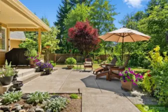 Imagine savoring Pacific Northwest summers in this beautiful backyard, featuring a covered porch perfect for barbecuing and plenty of space to run, play, and relax.