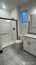 Basement bathroom with walk in shower, & large tile floors