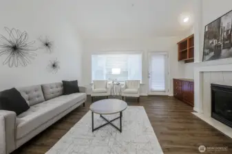 Spacious living room with vaulted ceilings, big gas fireplace, entertainment niche, door to the backyard, low maintenance, luxury vinyl plank thru out the main floor