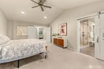 Primary bedroom with vaulted ceilings and ensuite bathroom.