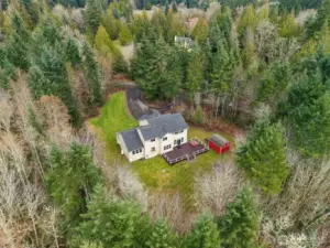 From above, this stunning home is beautifully tucked into a private, tree-filled setting, highlighted by a paved circular driveway that welcomes you to the property.