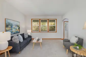 Enjoy the comfort of the spacious living room with peaceful, private views of the nature-filled front yard.